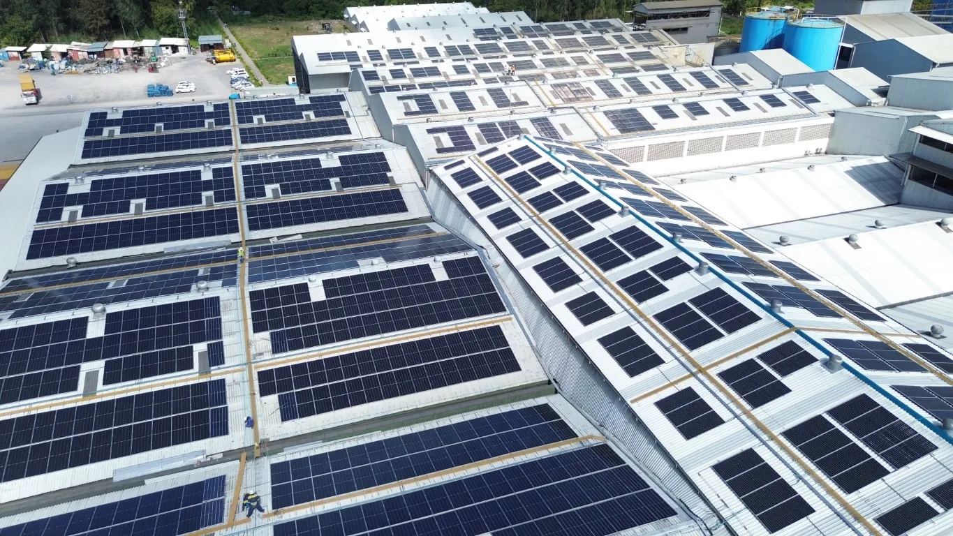 Aerial view of solar panels installed across multiple manufacturing roofs